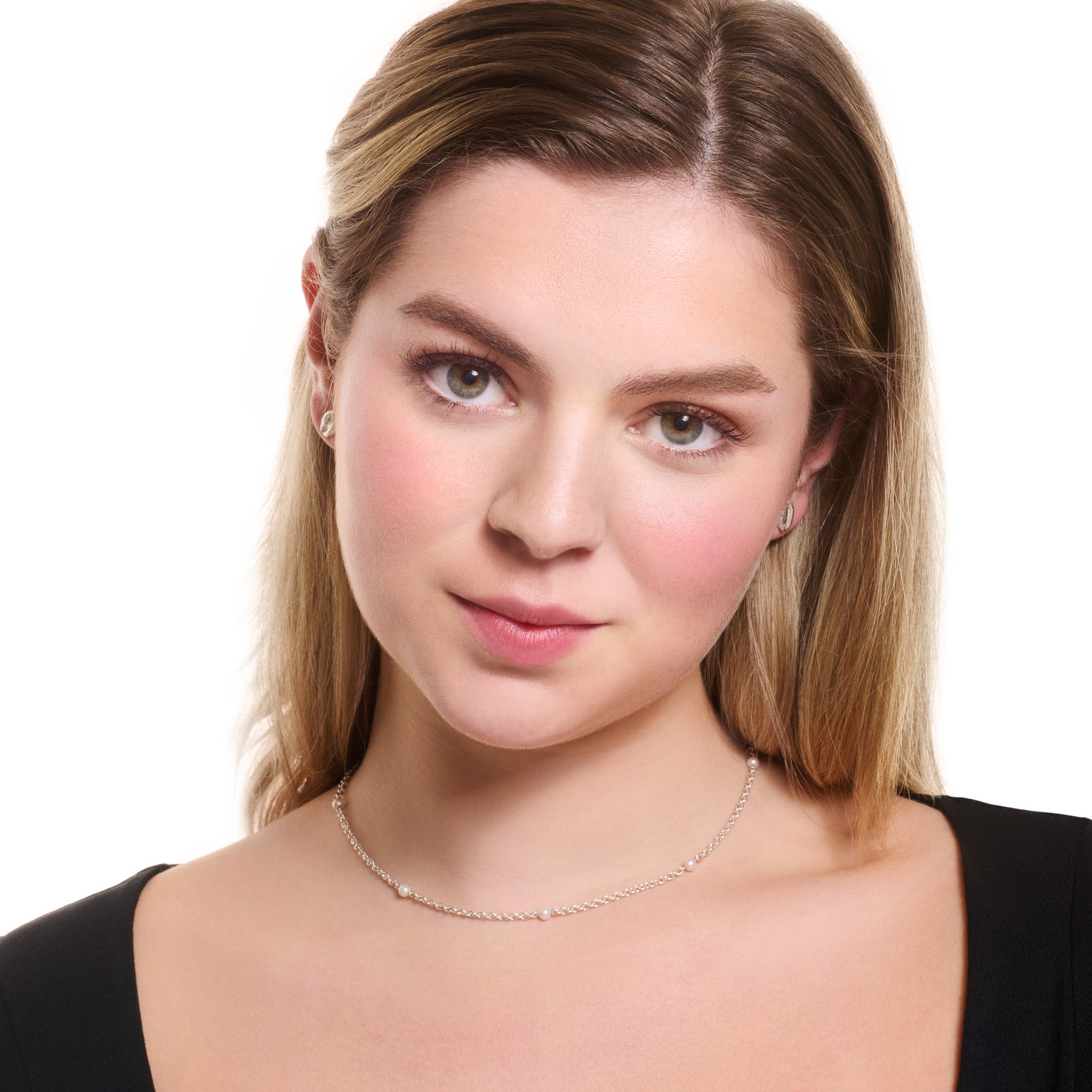 Model wearing a handcrafted sterling silver necklace chain featuring small circular links with pearls.