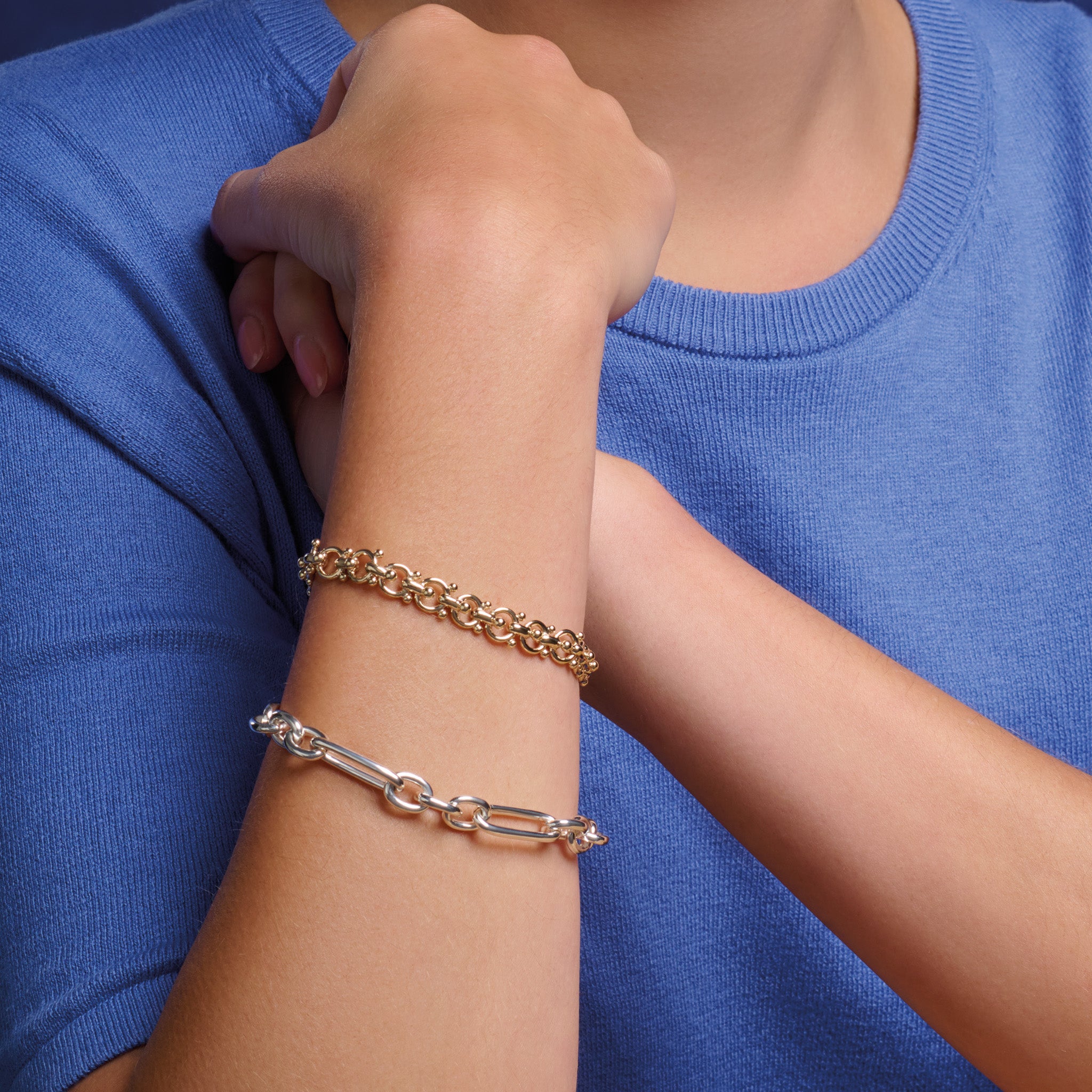 Model wearing handcrafted sterling silver link bracelet featuring chunky round and rounded rectangular links interconnected.