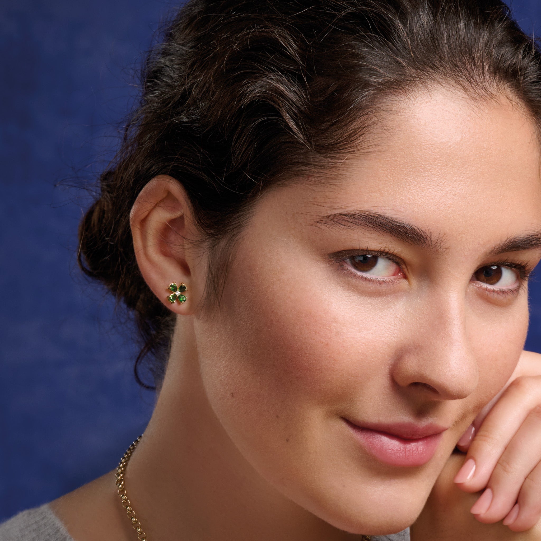 Model wearing handcrafted 9ct yellow gold four-leaf clover stud earrings with chrome diopside and diamond.