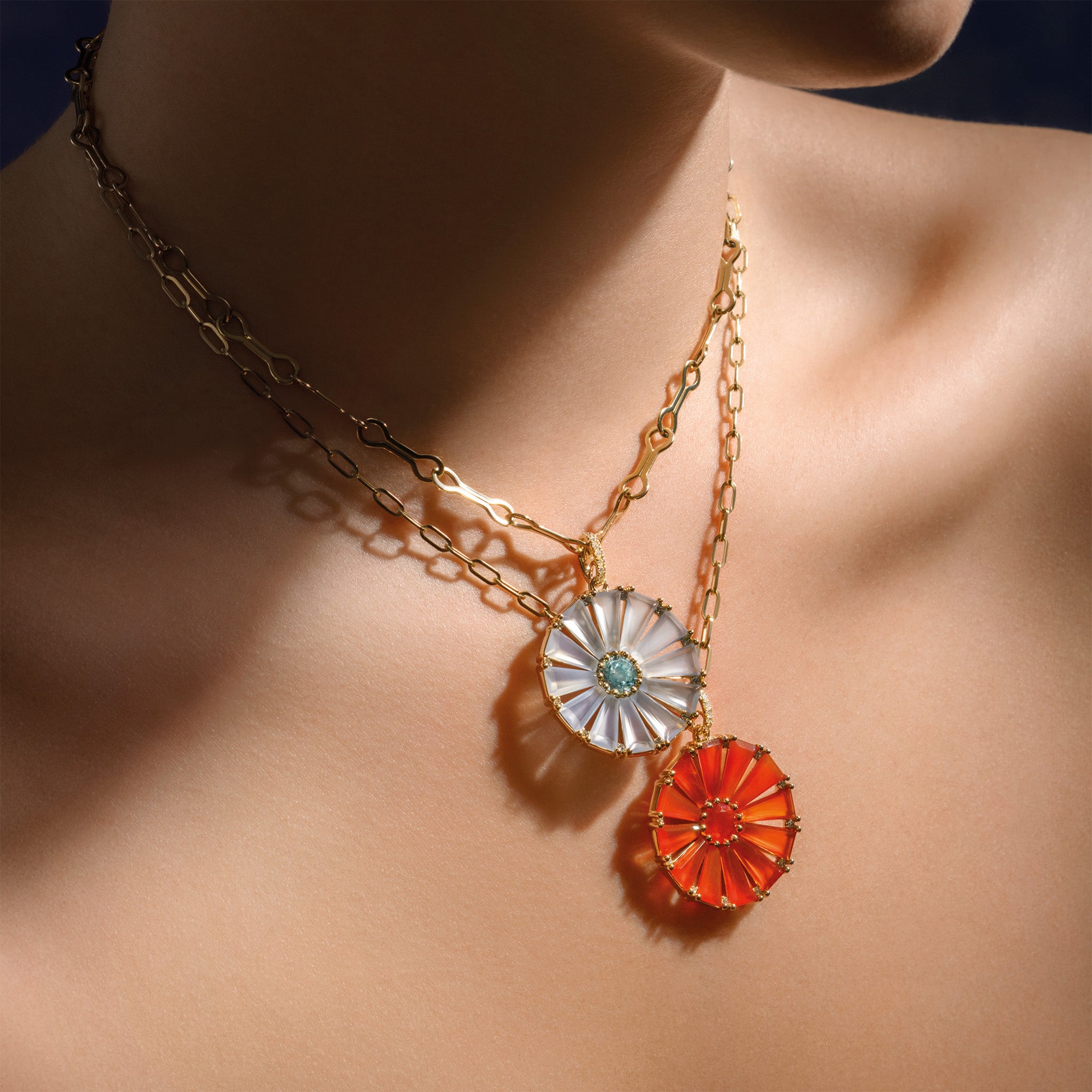 Model wearing a handcrafted yellow gold circular necklace pendant with baguette cut cornelian, fire opal and diamond gemstones.
