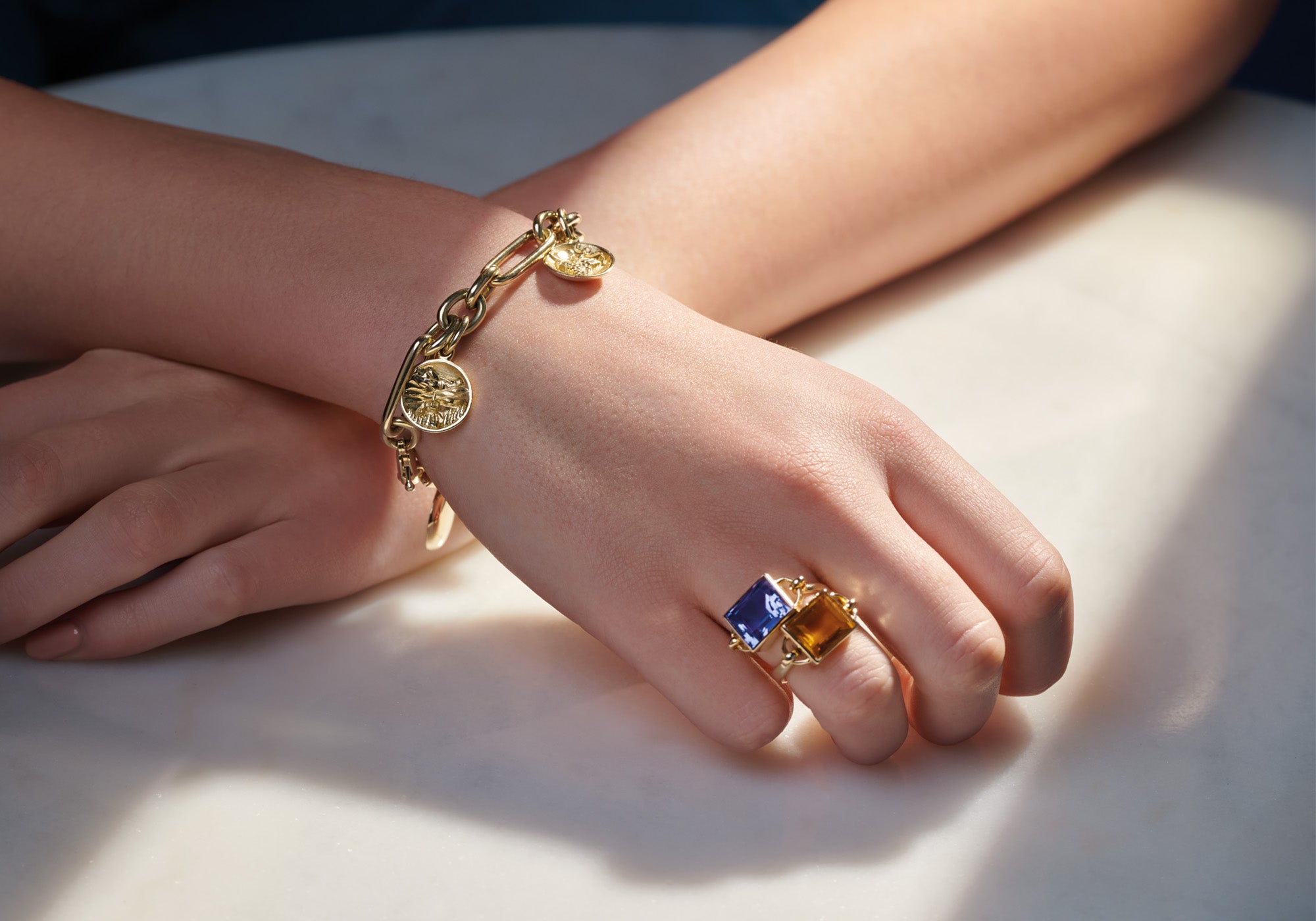 Model wearing handcrafted yellow gold ring featuring a baguette cut sapphire, perfect for a 45th wedding anniversary.