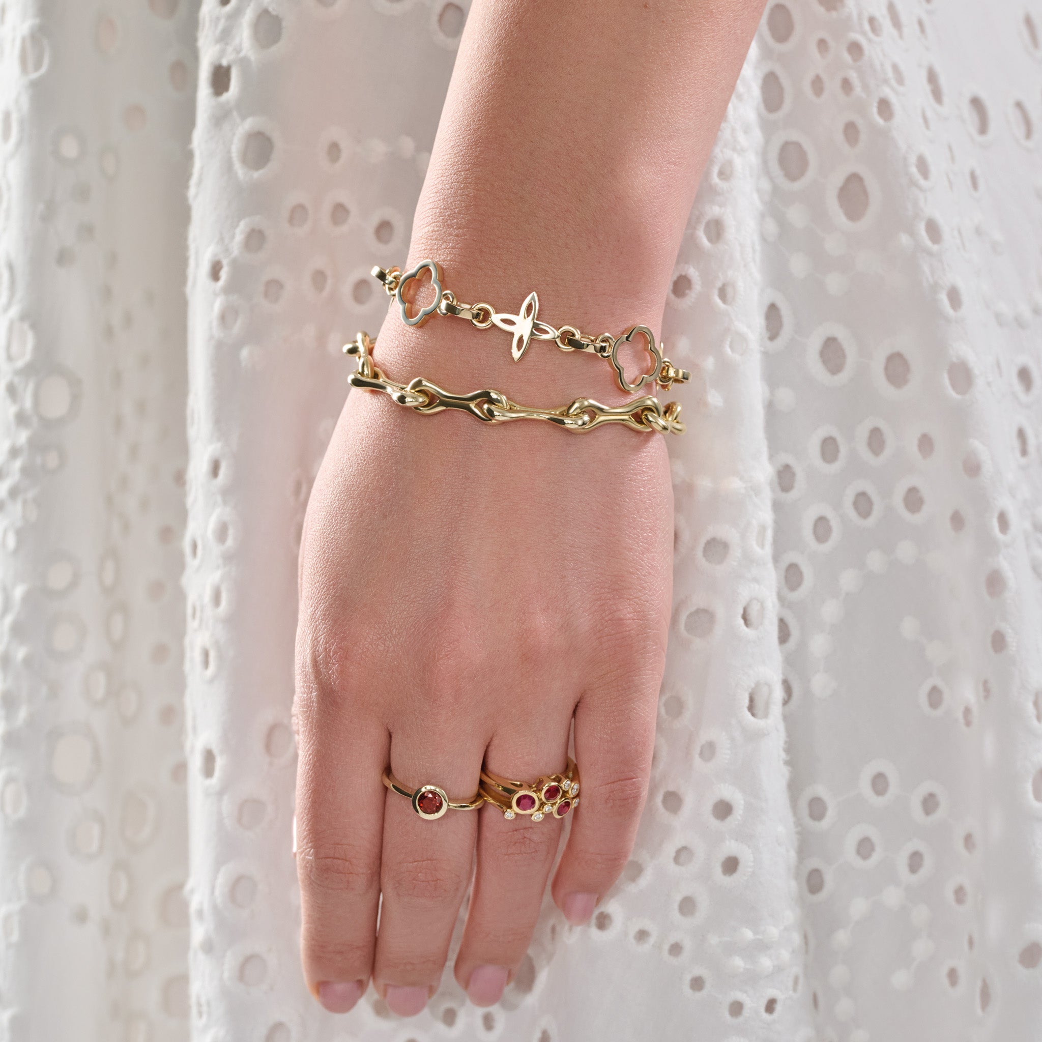 Model wearing a handcrafted yellow gold bracelet with star-shaped links.
