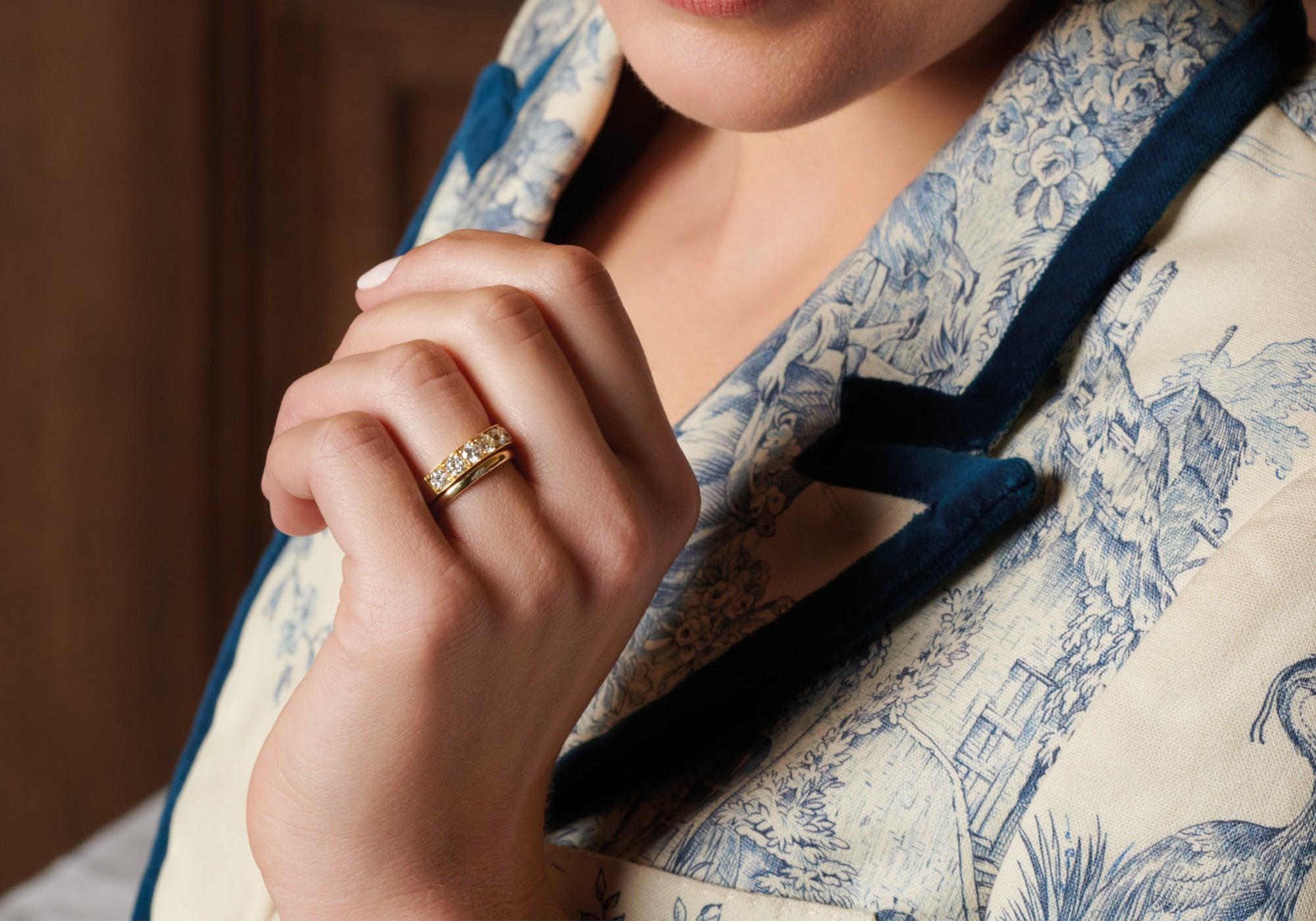 Model wearing handcrafted yellow gold gemstone and plain wedding bands.